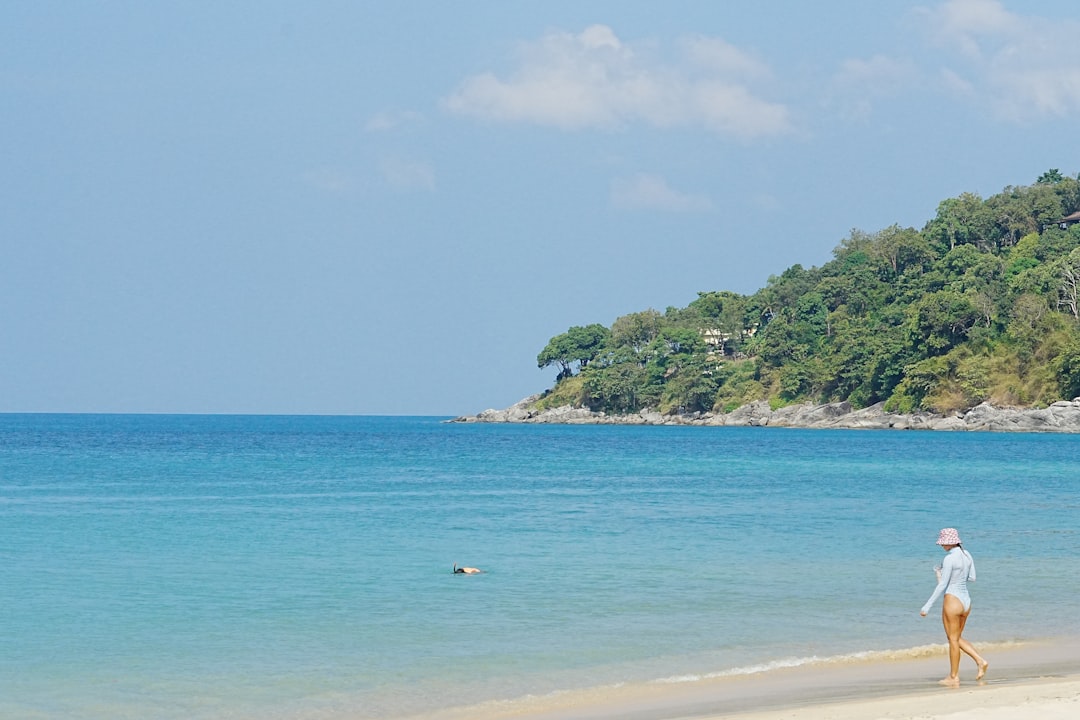 Nai Harn & Rawai Complete Scooter Explorer’s Guide 2026 2 Woman walking on a sandy beach by the ocean