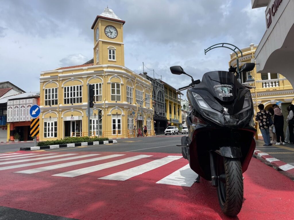 Motorbike Rental in Phuket Old Town 3 Black Honda PCX scooter at the red zebra crossing in front of the yellow heritage building in Phuket Old Town