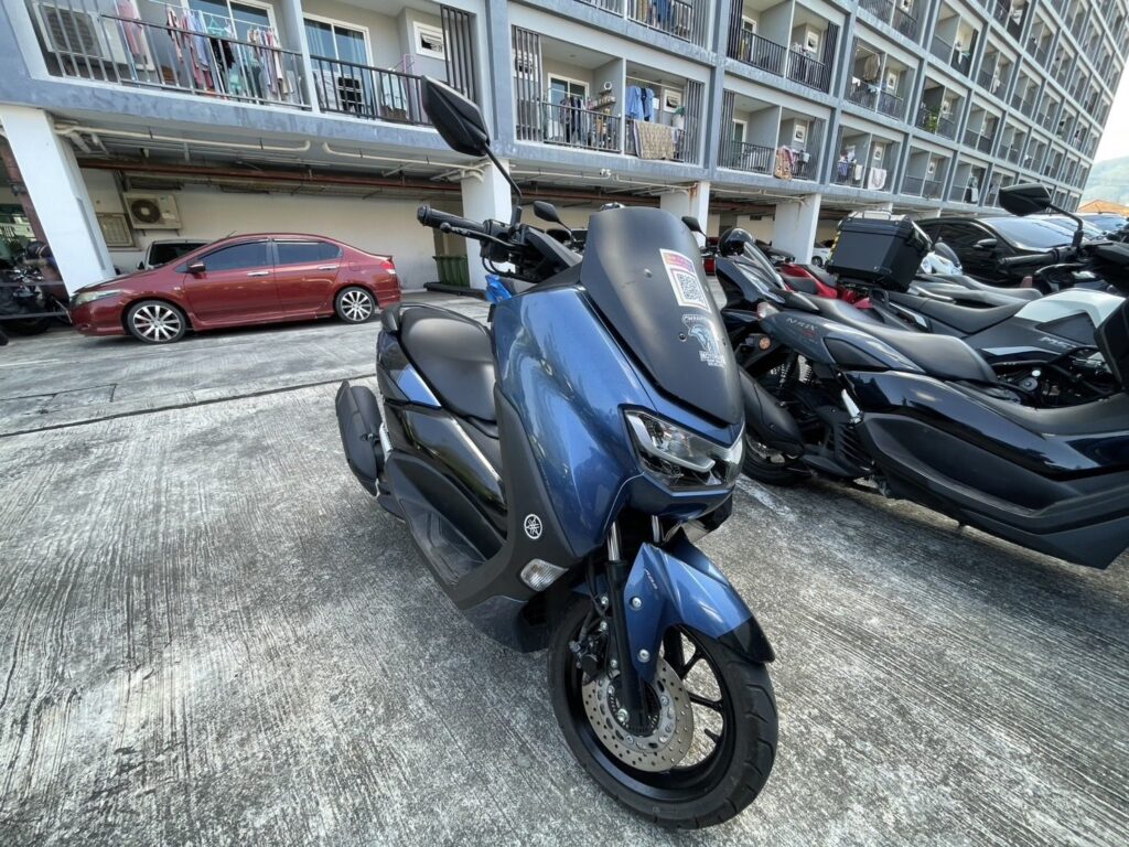 Motorbike Rental at Surin Beach 3 Blue Yamaha NMAX scooter parked with other rental scooters in front of a building
