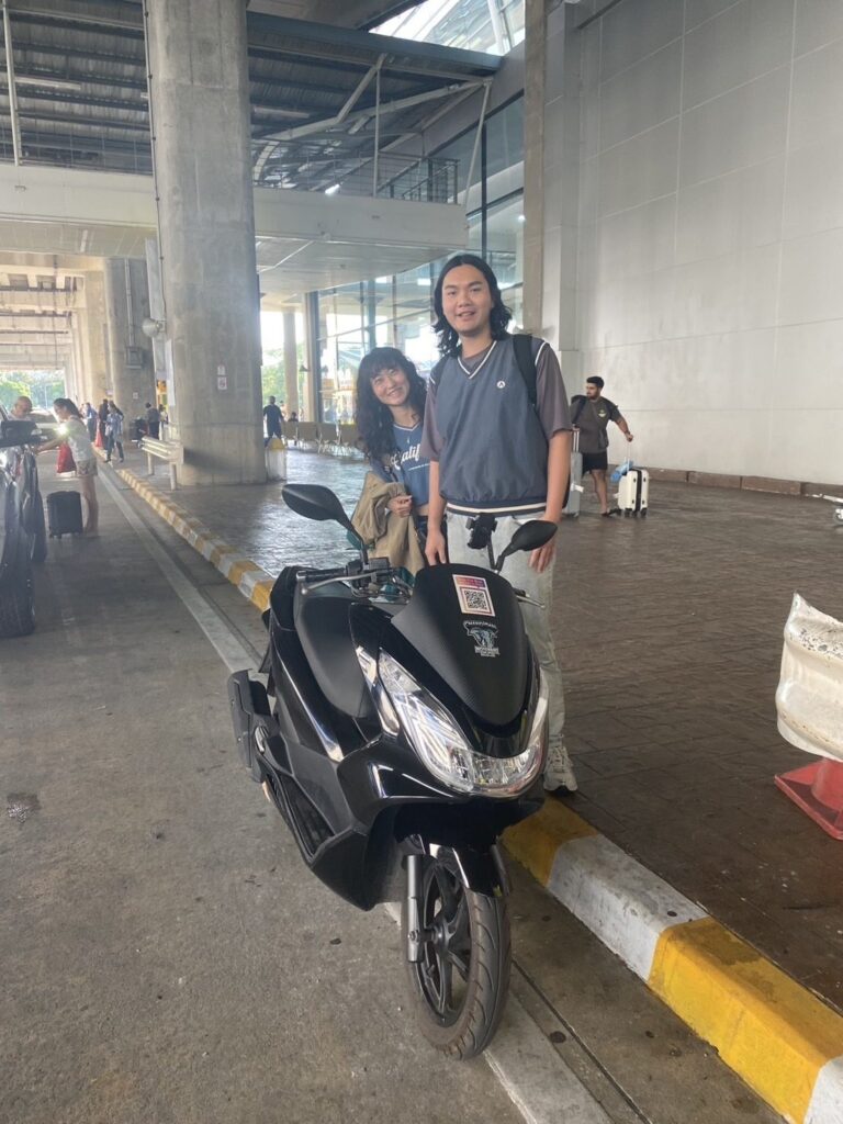 Motorbike Rental at Phuket International Airport 6 Customers with a black Honda PCX scooter outside the Phuket Airport terminal
