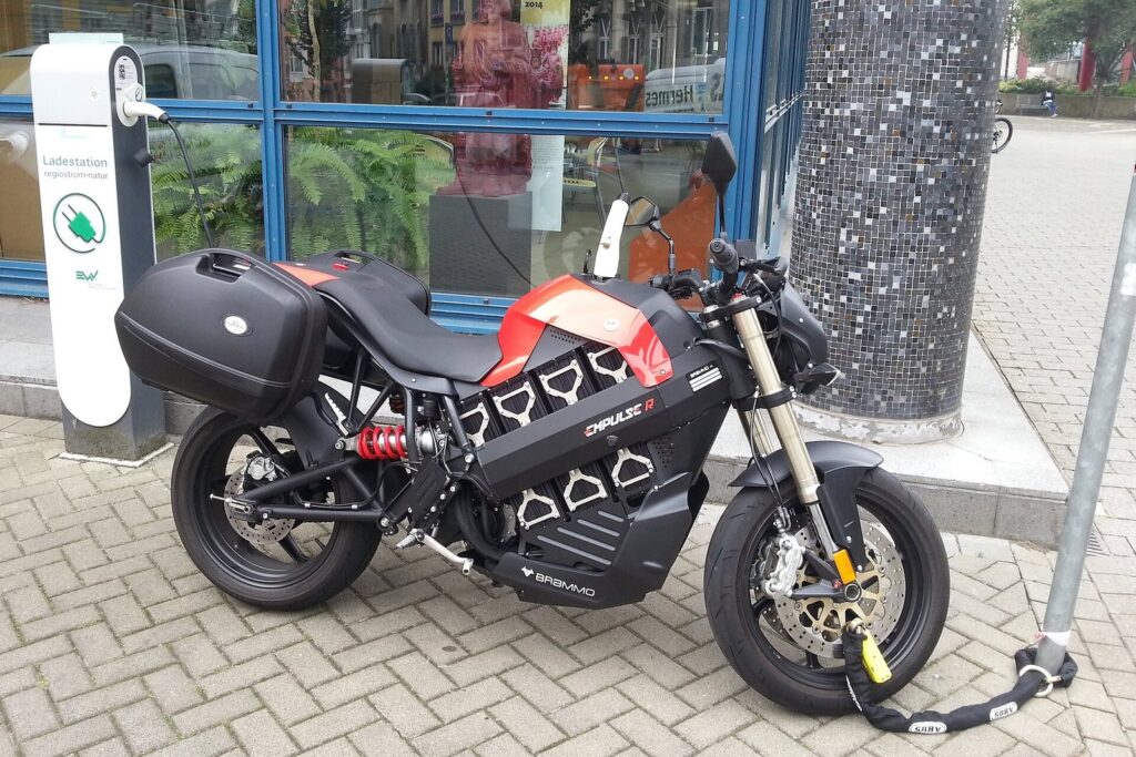 Electric Scooter Rental Phuket 2026 — What's Available, Honest Pros & Cons 3 Electric motorcycle locked next to a public charging point on a paved street