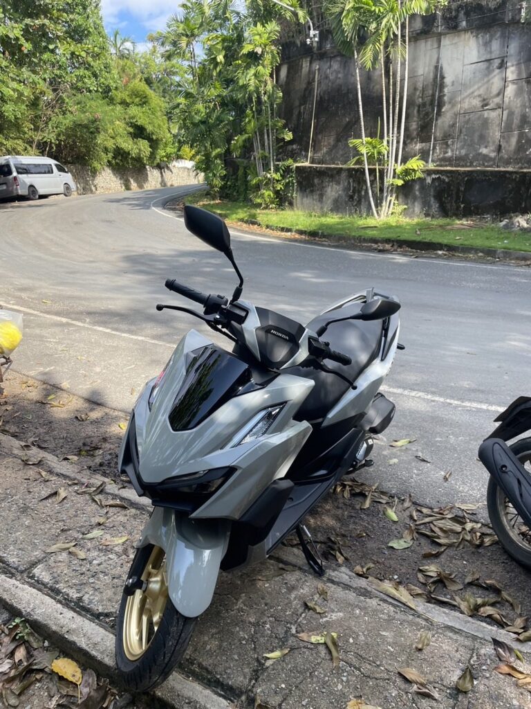 Motorbike Rental at Kata Noi 3 Grey Honda scooter with gold wheels parked at a bend on a Kata hill road