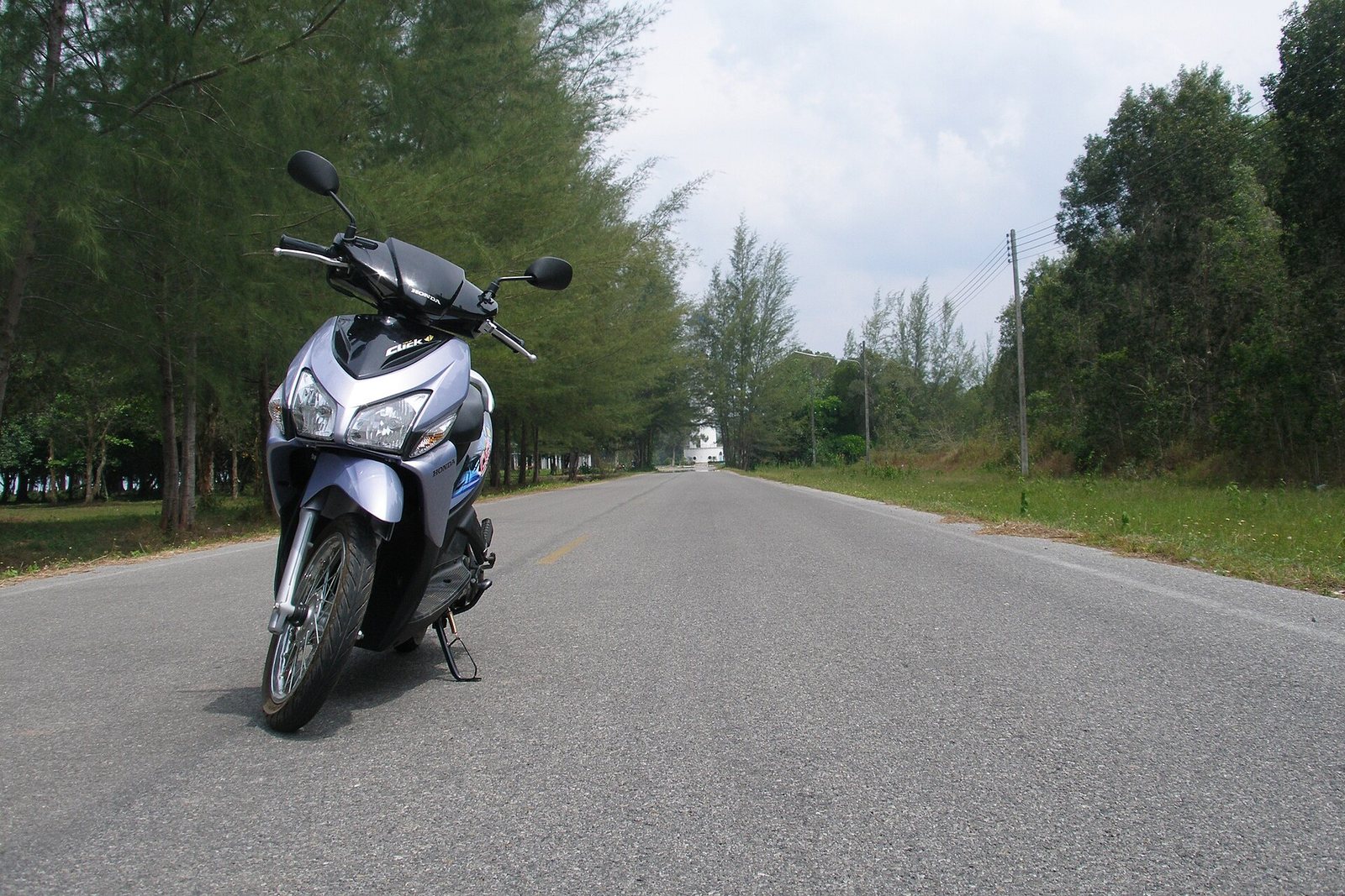 Stop Believing You Can Blast Your Honda Click 125 2026 Anywhere: The Truth About High-Pressure Washing 1 Honda Click scooter standing on an empty tree lined road in Trang, Thailand
