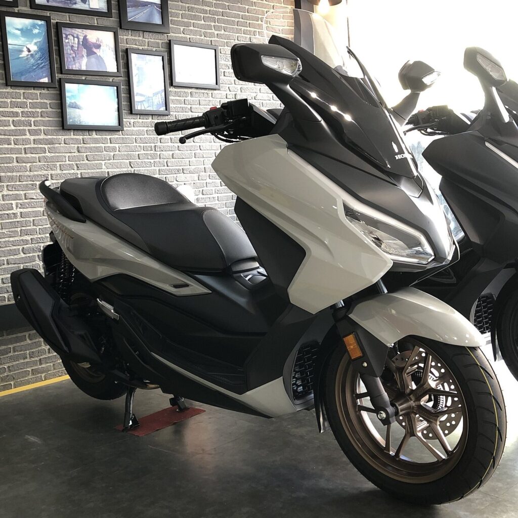 Honda ADV 350 vs Forza 350 — Phuket Rental Guide 2026 3 Honda Forza 350 maxi scooter in white and grey in a showroom