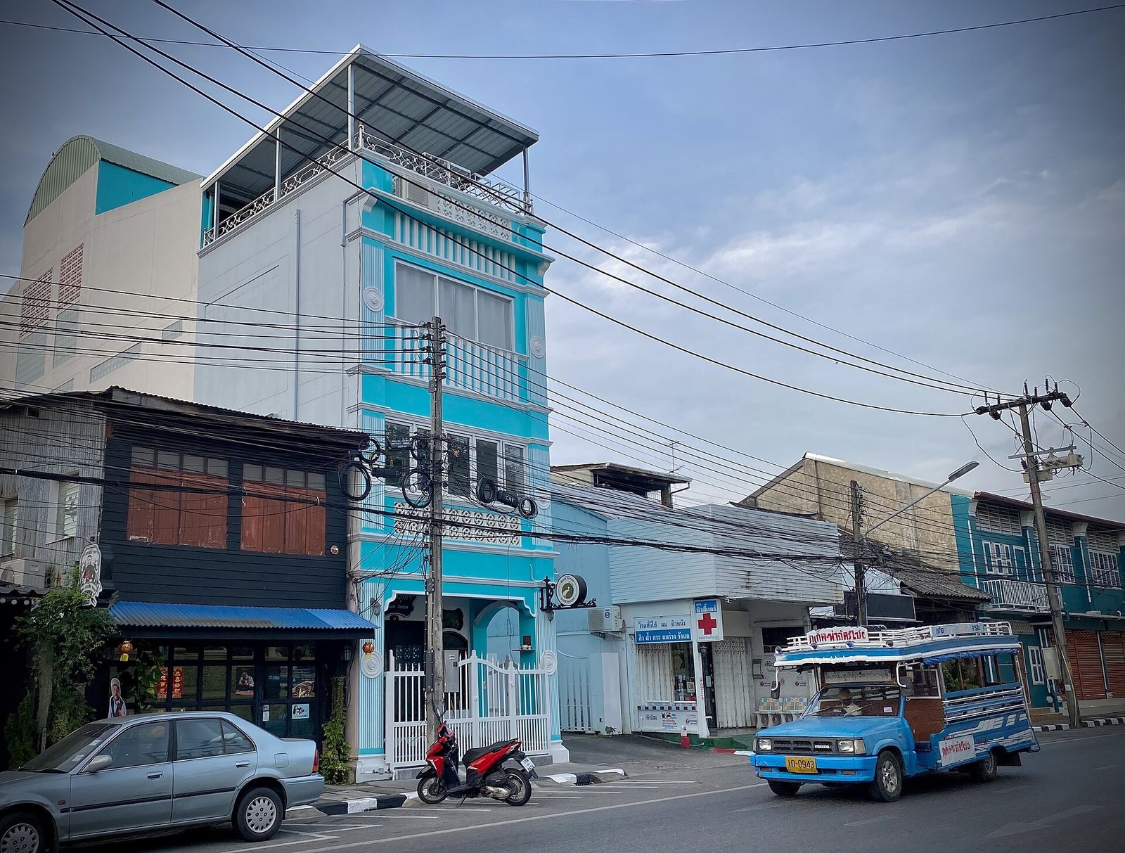 Blue local songthaew bus driving along a street in Phuket