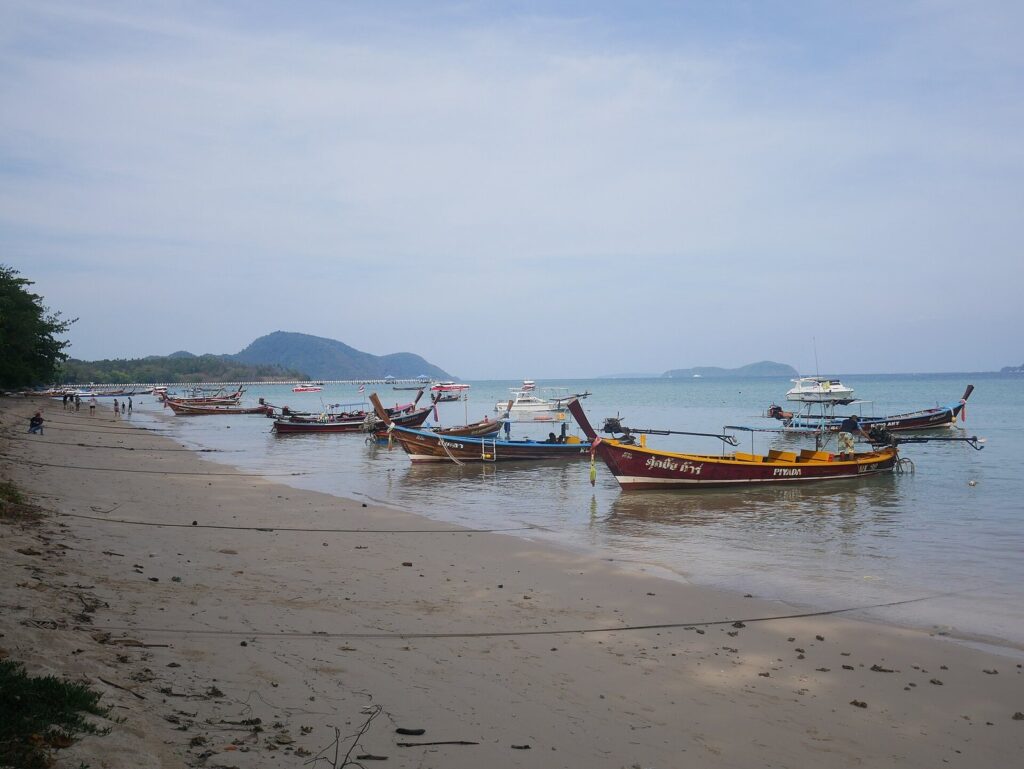 Phuket Scooter Route: Big Buddha, Promthep Cape & Rawai — Half-Day Guide 2026 4 Longtail boats pulled up on the sand at Rawai Beach in Phuket