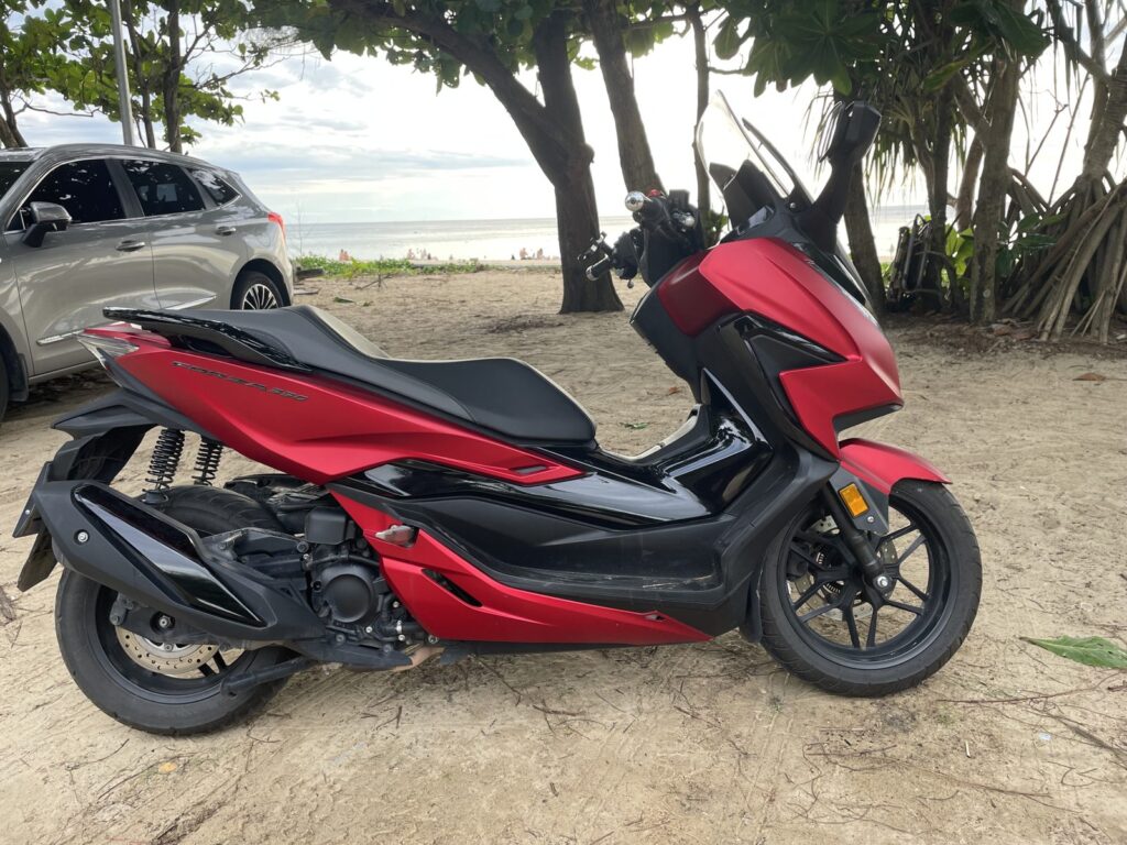 Motorbike Rental at Karon Beach 3 Red Honda Forza 350 big scooter parked under trees at Karon Beach