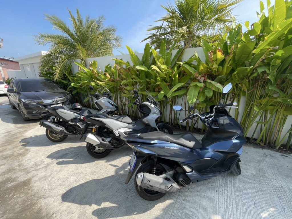 Motorbike Rental at Kamala Beach 3 Honda PCX and ADV rental scooters parked in a Kamala villa car park among palm plants