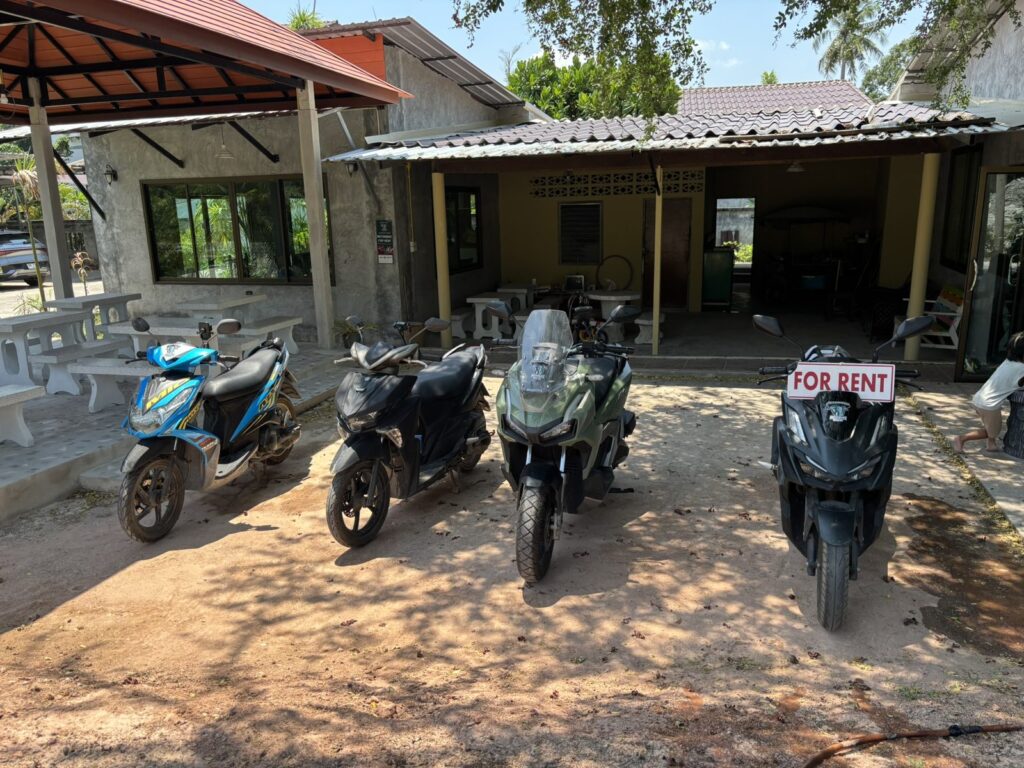 Motorbike Rental at Mai Khao 3 Rental scooters with FOR RENT tags parked in front of the Chang Thai Mai Khao branch