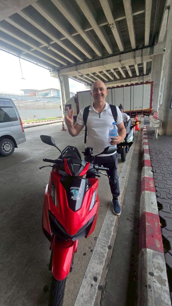 Motorbike Rental at Phuket International Airport 9 Rider on a red Honda scooter under the covered walkway at Phuket Airport