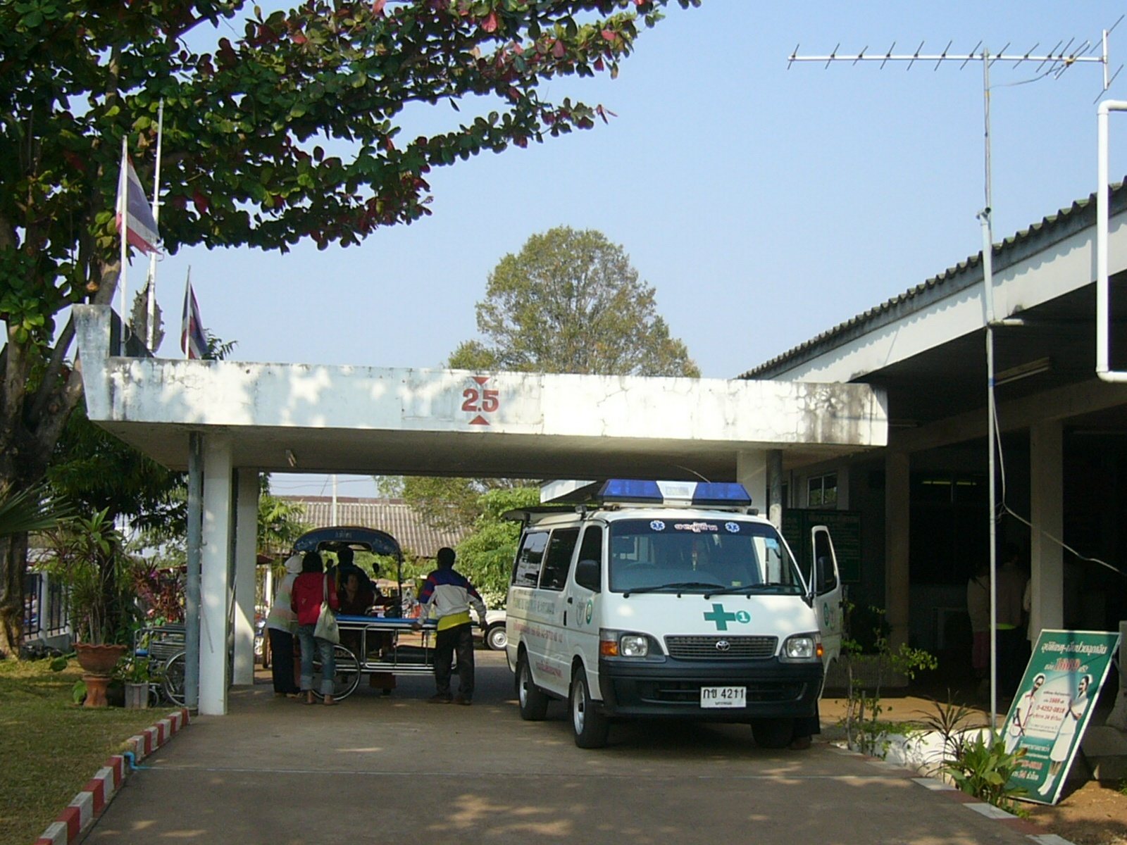 Emergency entrance of a public hospital in Thailand with an ambulance parked under the canopy