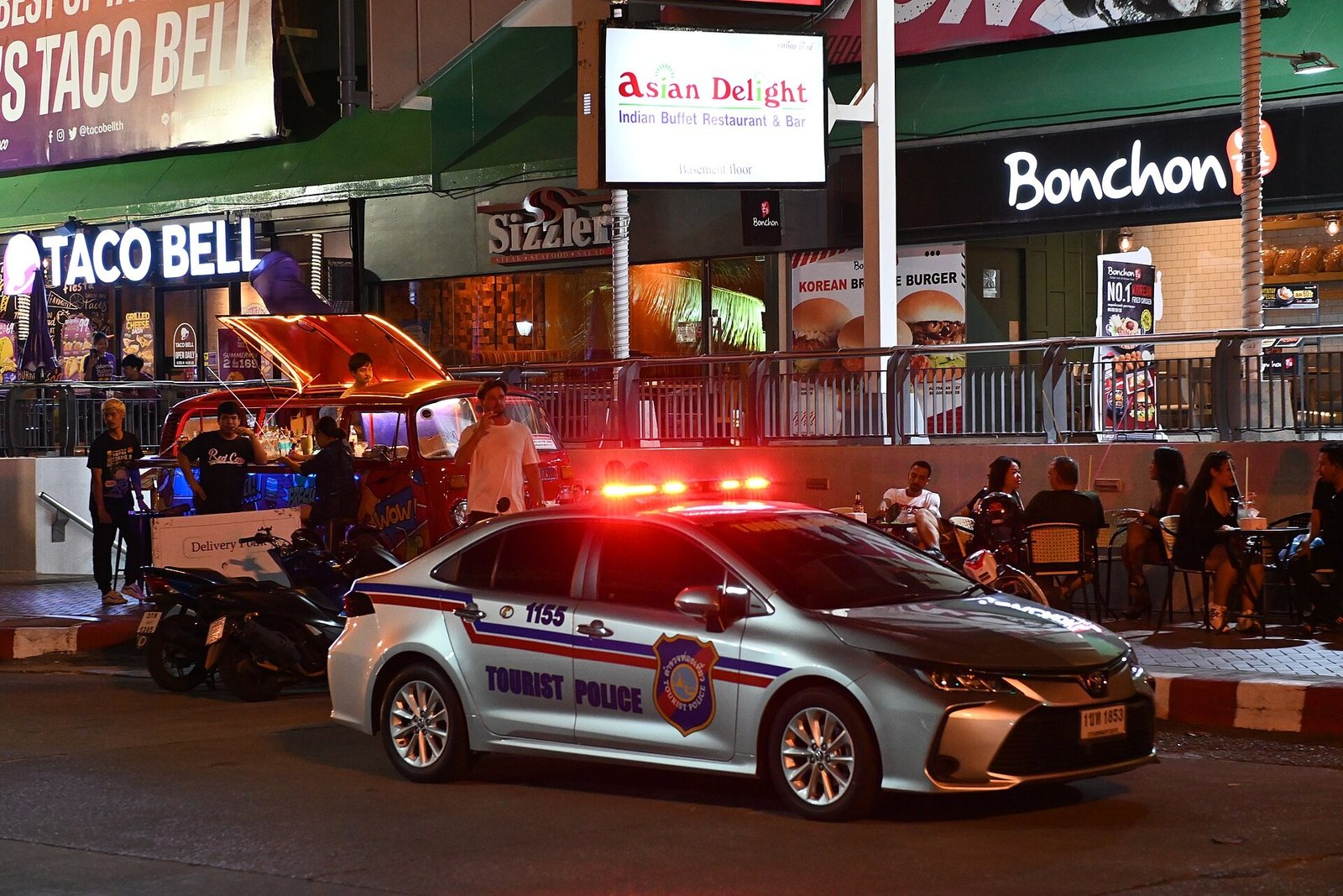 Thai Tourist Police patrol car with lights on in a busy tourist street at night