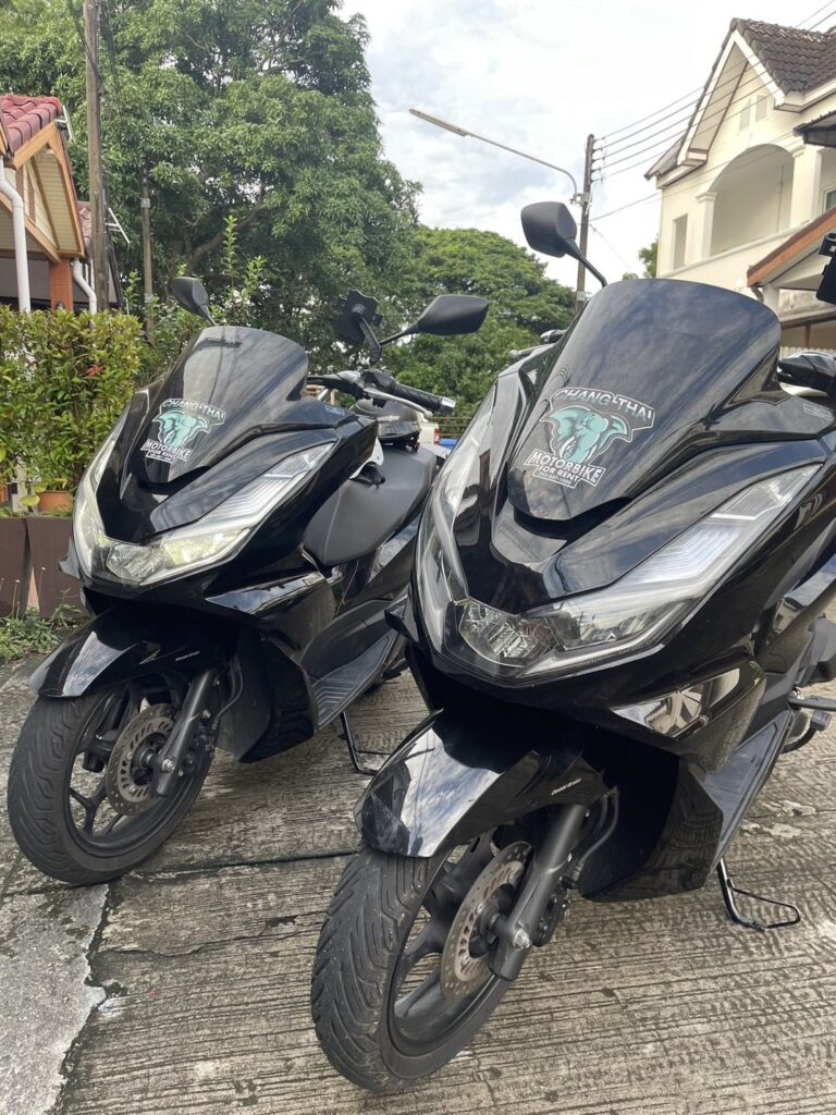 Motorbike Rental at Cape Panwa 2 Two black Honda PCX rental scooters parked beside a house in Cape Panwa