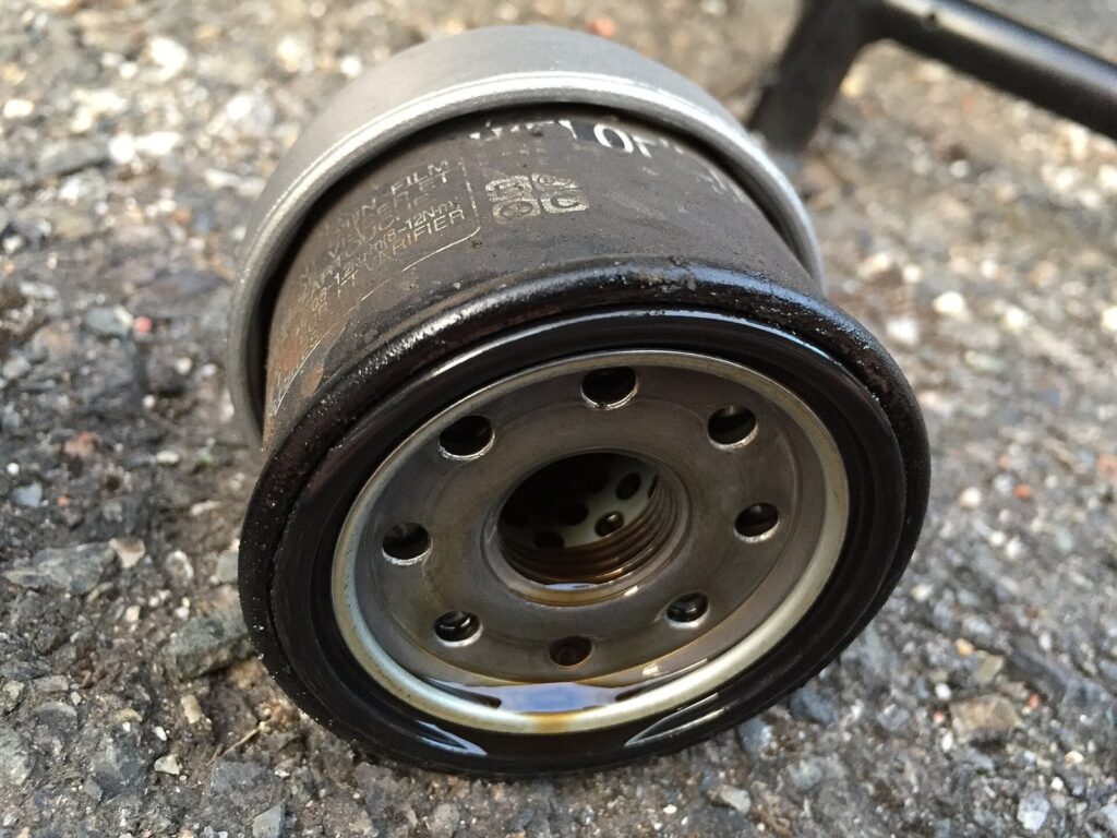 How to Change Oil on Your Honda ADV 160: The Complete Guide That Actually Works 1 Old used motorcycle engine oil filter removed during an oil change