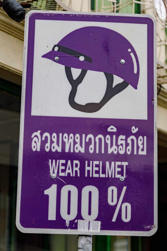 Safe Riding Techniques for First-Time Scooter Riders in Phuket 2 Purple Wear Helmet 100% road sign in Thai and English in Phuket, Thailand
